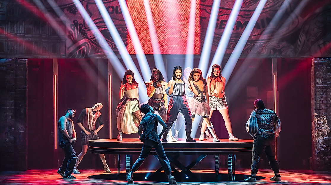 Szenenbild & Julia: Cast tanzend auf einem Podest, Lichteffekte im Hintergrund. 