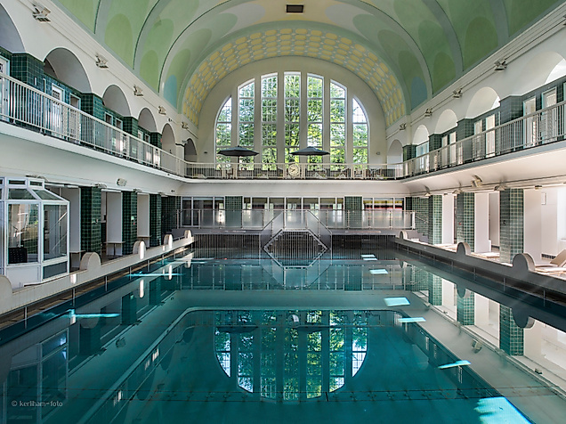 Der Innenraum des Holthusenbad mit Fensterfront und großem Schwimmbecken.