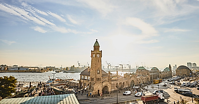 Landungsbrücken mit Uhrturm und Elbe im goldenen Licht der tief stehenden Abendsonne