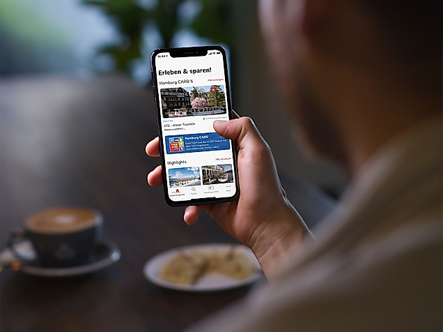 Mann benutzt Hamburg App – Erleben & Sparen im Café