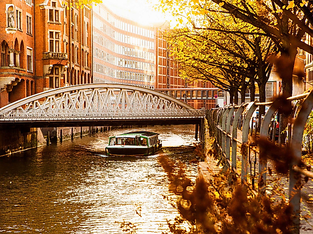 Barkasse in der herbstlichen Speicherstadt bei Sonnenlicht – Ausflugstipp für eine Fahrt durch Hamburgs Fleete