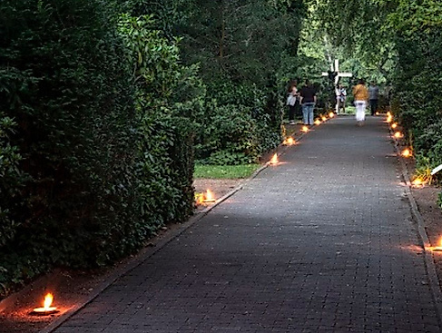 Kerzen rechts und links von einem Weg auf dem Alten Friedhof in Mölln