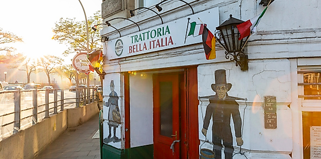 Außenansicht eines italienischen Restaurants in Hamburg mit Wandbemalung und Blick auf die Elbe im Abendlicht