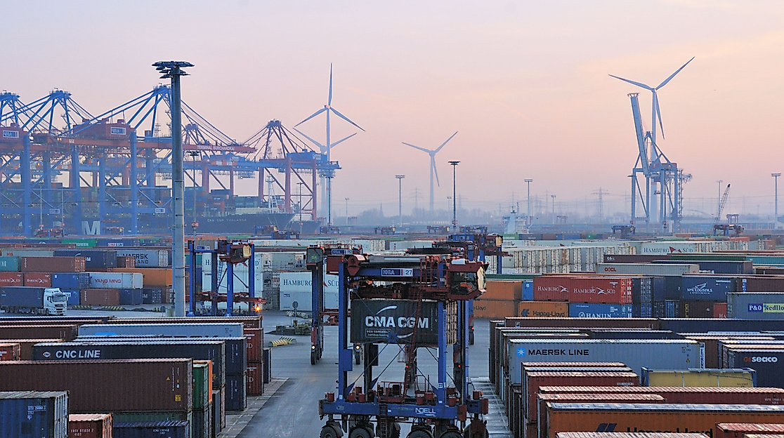Containerterminal im Hamburger Hafen bei Morgendämmerung mit Containern, Kränen und Transportfahrzeugen