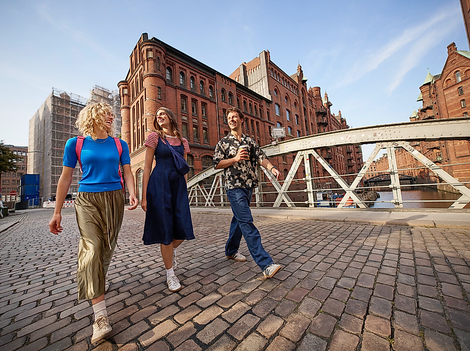 Drei junge Erwachsene gehen in der Speicherstadt spazieren
