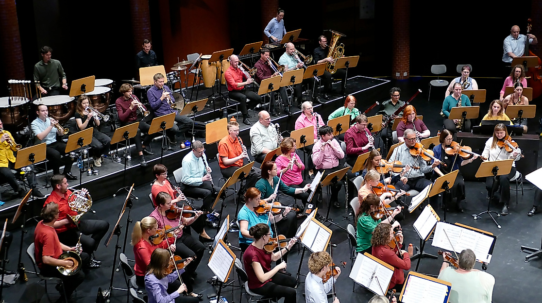 Spielendes Orchester in bunter Kleidung von der Seite