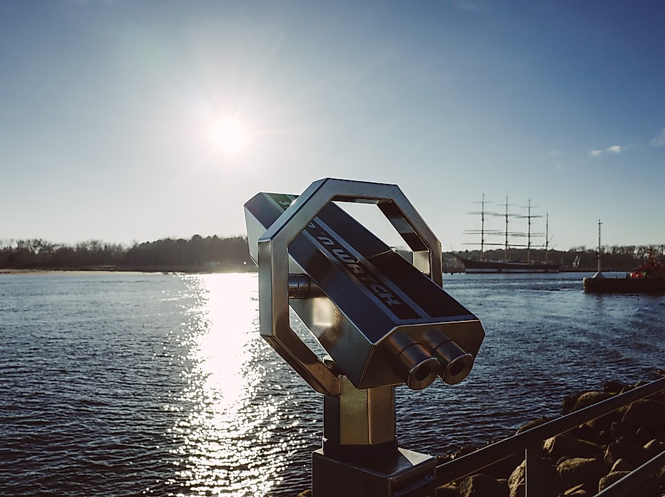 Aussichtsfernrohr am Hamburger Hafen mit Blick auf die Elbe bei tiefstehender Sonne