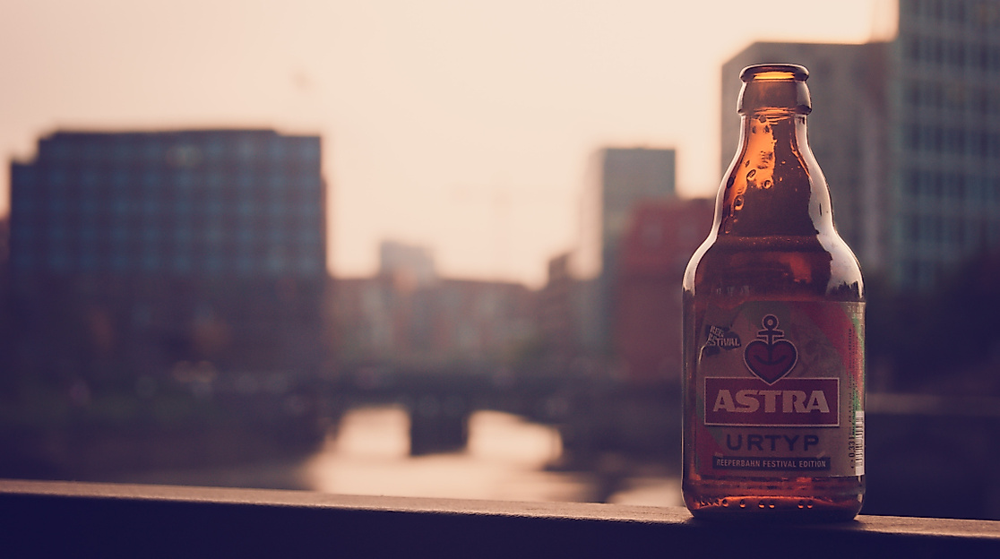 Astra Bierflasche vor Hamburger Hintergrund, der verschwommen ist 