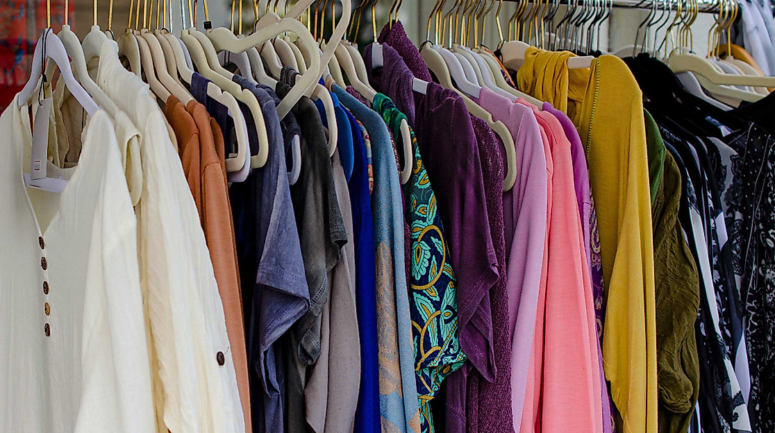 Bunte Auswahl an Second-Hand-Kleidung auf einer Kleiderstange in einem Hamburger Vintage-Laden