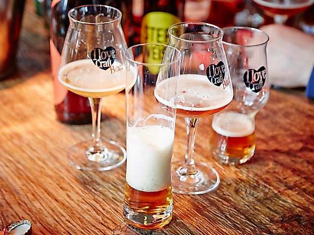 Verschiedene Biersorten in Verkostungsgläsern auf Holzplatte beim Bockbeerday serviert