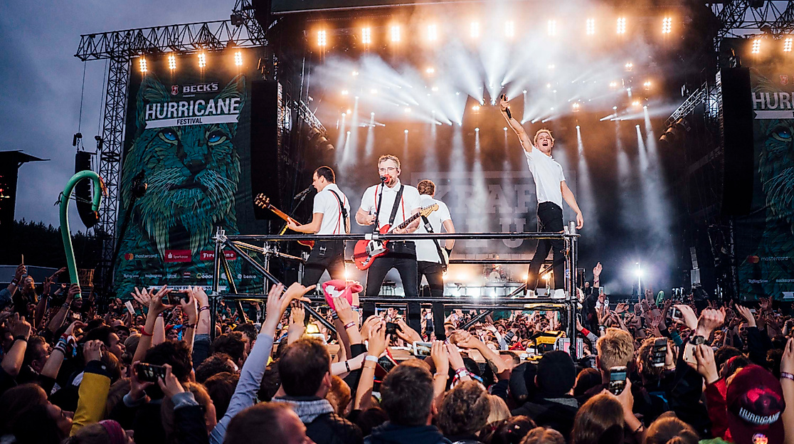 Festivalpublikum vor großer Bühne mit Band und Lichtshow beim Hurricane Festival