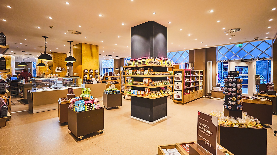 Heller Verkaufsbereich im Chocoversum Hamburg mit Regalen voller Schokoladenprodukte und Geschenkartikel