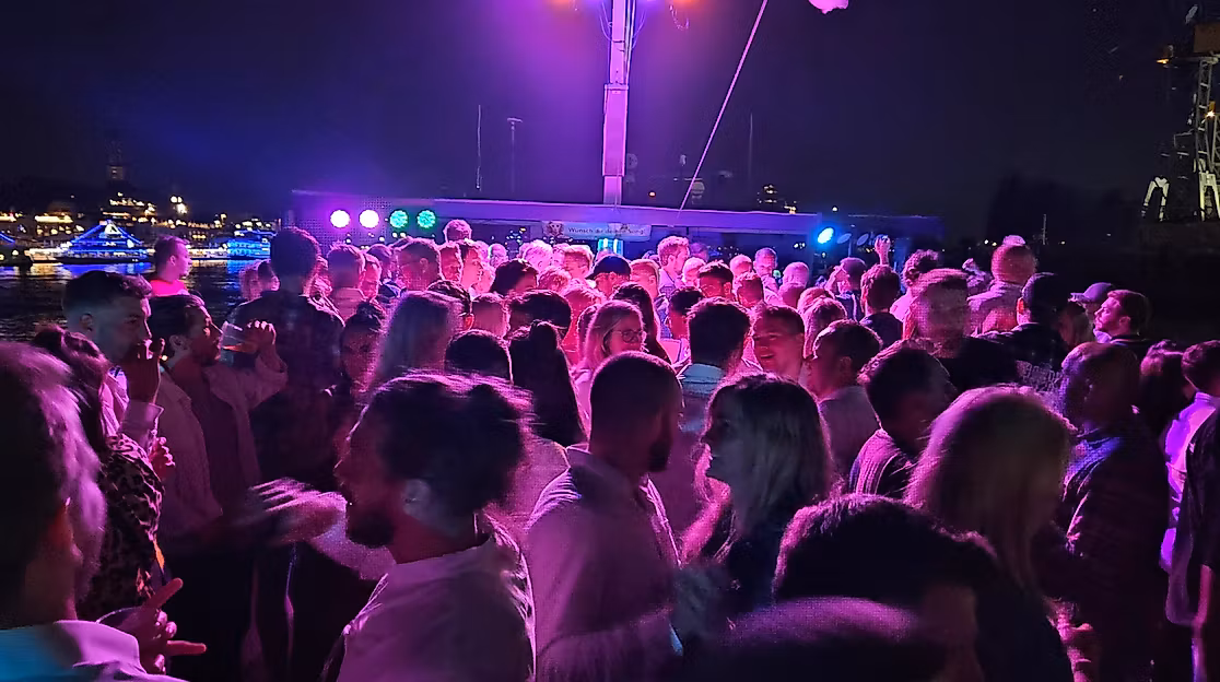 Das Partyschiff fährt durch den beleuchteten Hamburger Hafen
