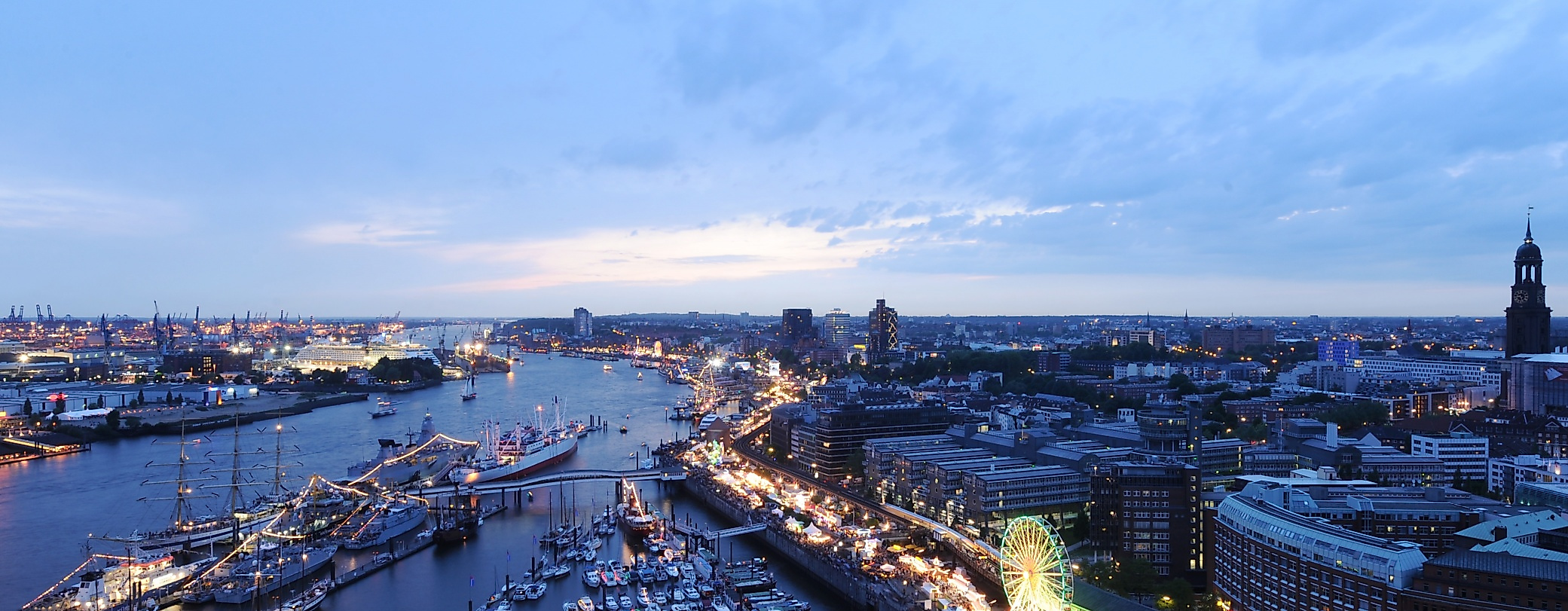 Abendblick auf den Hamburger Hafen mit beleuchteter Uferpromenade und festlich geschmückten Schiffen