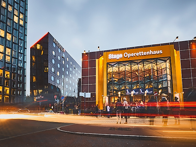 Beleuchtetes Stage Operettenhaus auf der Reeperbahn bei Abenddämmerung mit Lichtspuren vorbeifahrender Autos
