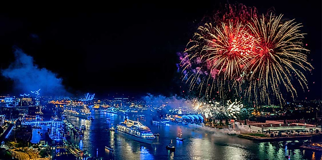 Ein farbenfrohes Feuerwerk über dem nächtlich erleuchteten Hamburger Hafen während der Cruise Days – festliche Lichter spiegeln sich im Wasser, Kreuzfahrtschiffe liegen stimmungsvoll beleuchtet am Kai.