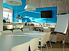 Modern gestalteter Coworking-Space in Hamburg mit großem Tisch, Flipchart und TV in kreativem Ambiente.
