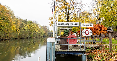 Anleger im Biergarten Zum Anleger am Harburger Kanal, umgeben von herbstlich gefärbten Bäumen