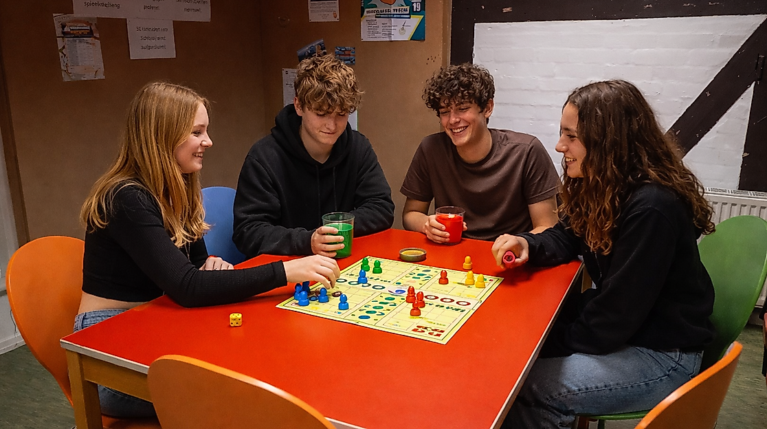 Jugendliche spielen Mensch-Ärgere-Dich-Nicht
