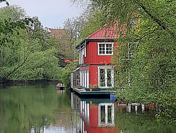 Rotes Hausboot am Ufer des Isebekkanals