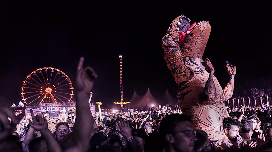 Nachtfestival mit feiernder Menge und beleuchtetem Riesenrad