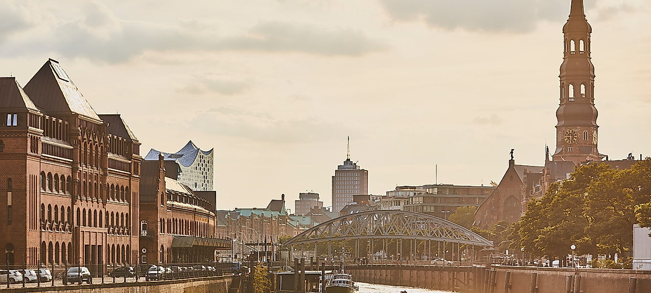 Abendstimmung in der Hamburger Speicherstadt mit Blick auf Kanal, historische Gebäude und Kirchturm