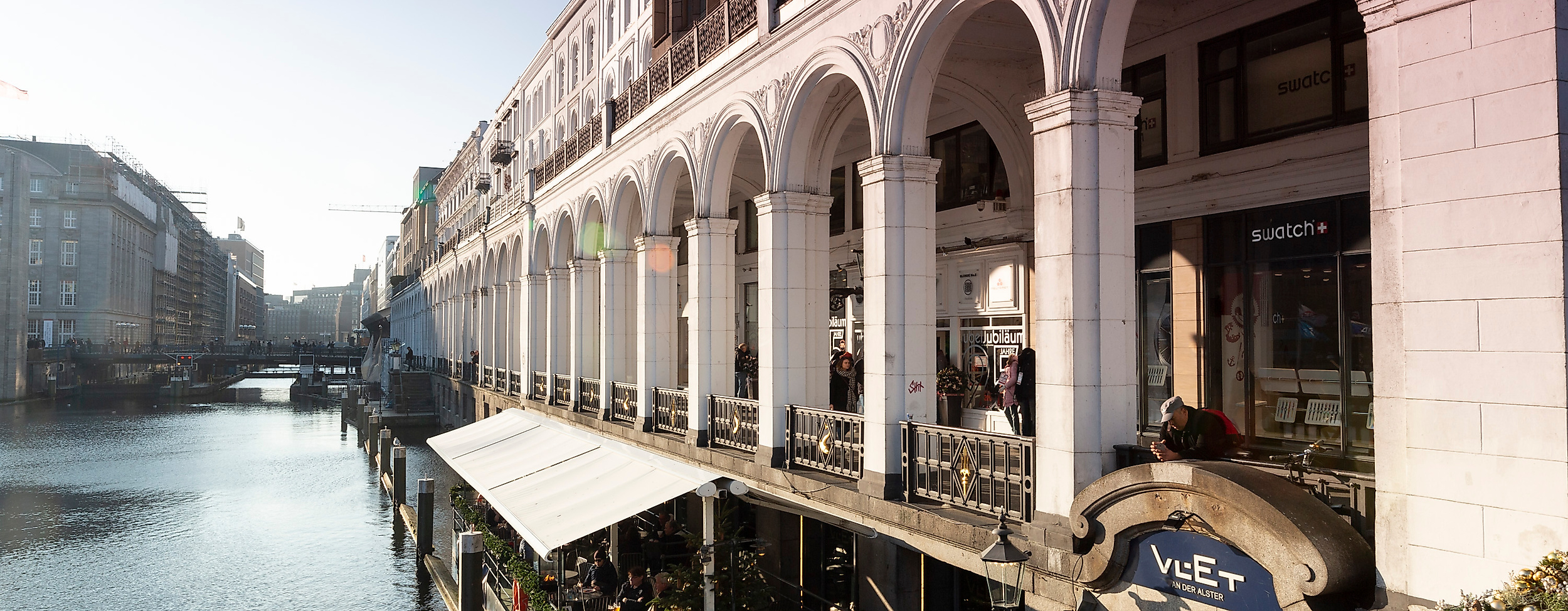 Alsterarkaden in Hamburg mit historischen Arkadenbögen und Außenterrassen direkt am Wasser