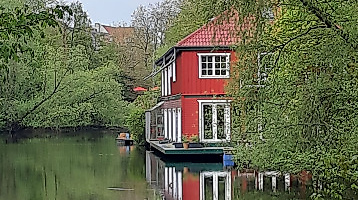 Rotes Hausboot am Ufer des Isebekkanals