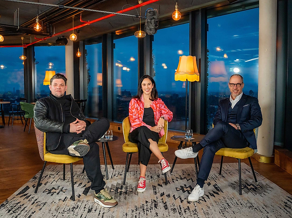Tim Mälzer, Michael Otremba und eine Moderatorin sitzen entspannt in Lounge-Atmosphäre mit Panorama-Ausblick beim Hamburg Horizonte Talk