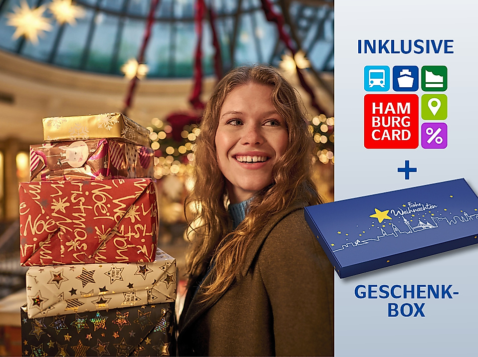 Frau mit Geschenken in der Hand in einer weihnachtlichen Einkaufspassage