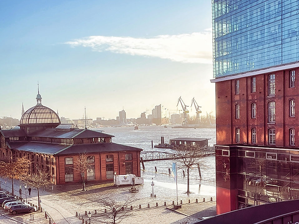 Blick auf das GINN Hotel Hamburg Elbspeicher, die Fischauktionshalle und den Hafen bei Sonnenaufgang