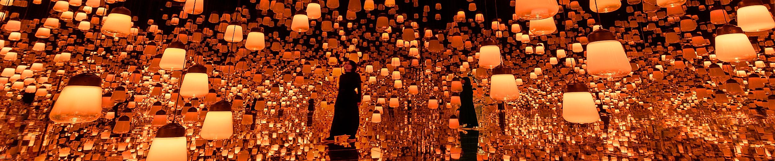 Leuchtende Lampen schaffen eine magische Atmosphäre im UBS Digital Art Museum bei teamLabs „Forest of Resonating Lamps“.