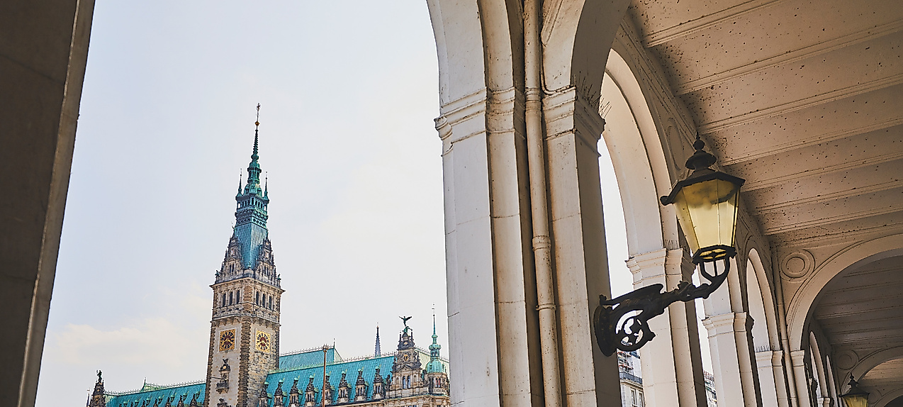 Blick durch die Alsterarkaden auf das Hamburger Rathaus mit markantem Turm