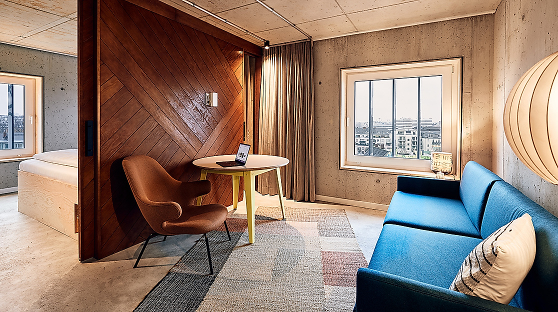 Blick auf Loungebereich mit blauem Sofa und braunem Stuhl