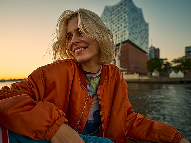 Frau auf Barkasse vor Elbphilharmonie Hamburg