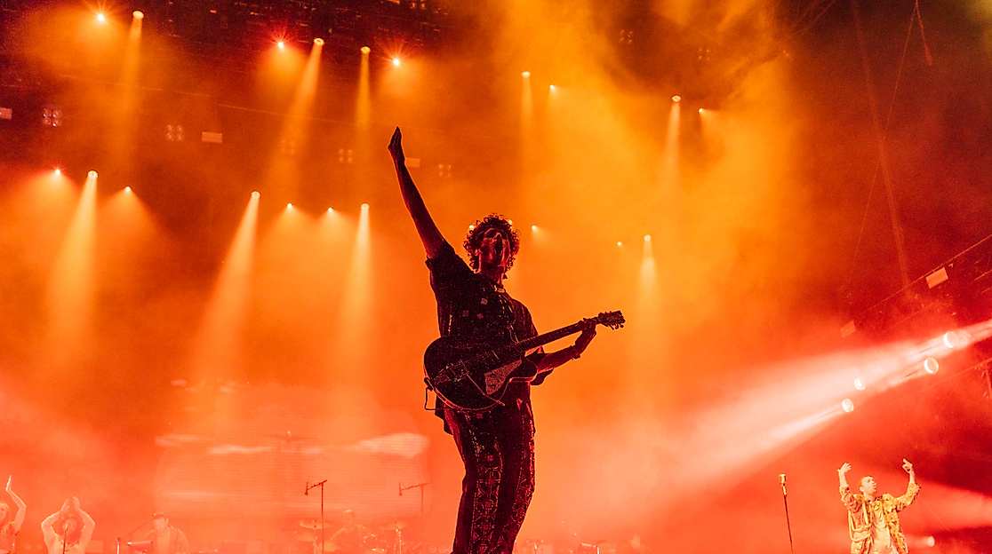 Gitarrist im Gegenlicht auf rot beleuchteter Bühne, energiegeladene Stimmung beim Hurricane Festival.
