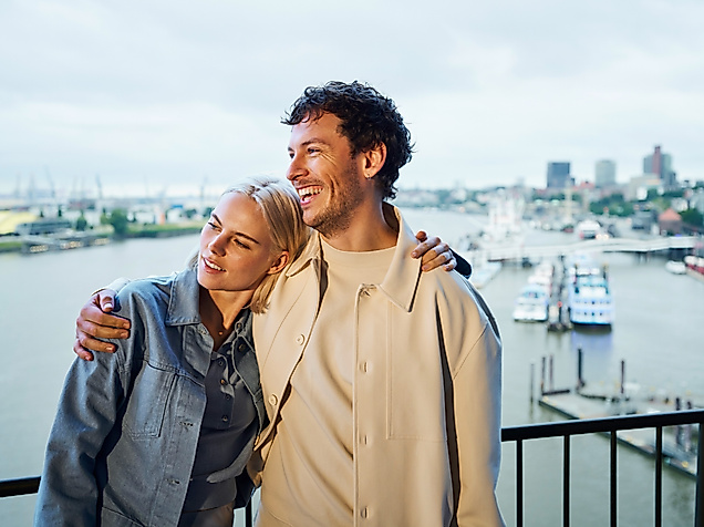 A couple stands arm in arm on the viewing platform of the Elphi.