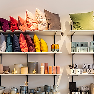 Regale mit bunten Kissen, Kerzen und Wohnaccessoires in einem Hamburger Design- und Einrichtungsladen