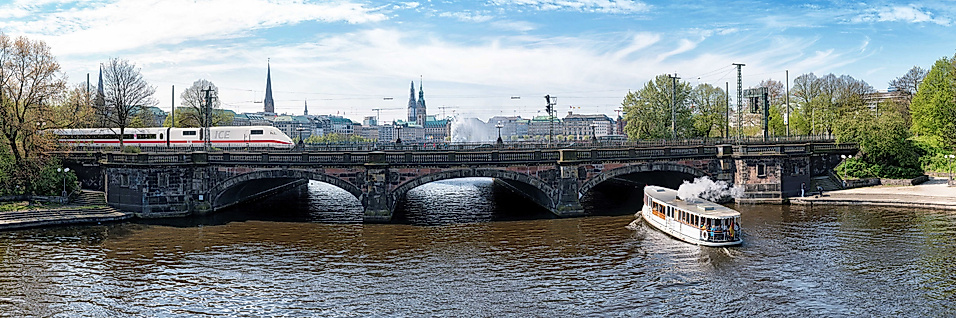 Panoramablick auf die Kennedybrücke in Hamburg mit Alsterbooten und Skyline im Hintergrund