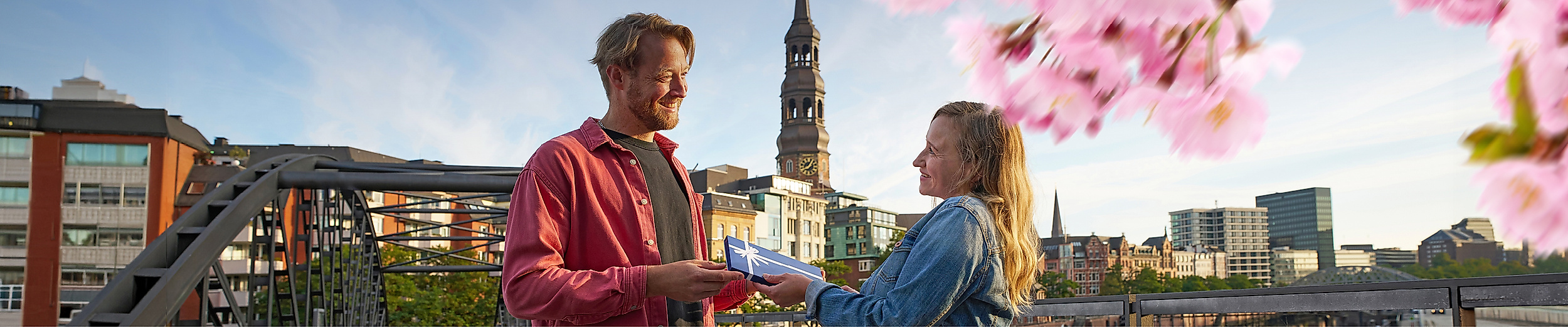 Ein Mann überreicht einer Frau einen Hamburg Gutschein