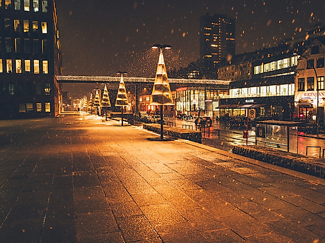 Christmas lights reflecting on wet cobblestones at night in a festively lit Hamburg street