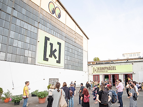 FFoto von der Kampnagel Piazza mit neon gelbem Kampnagel Logo.
