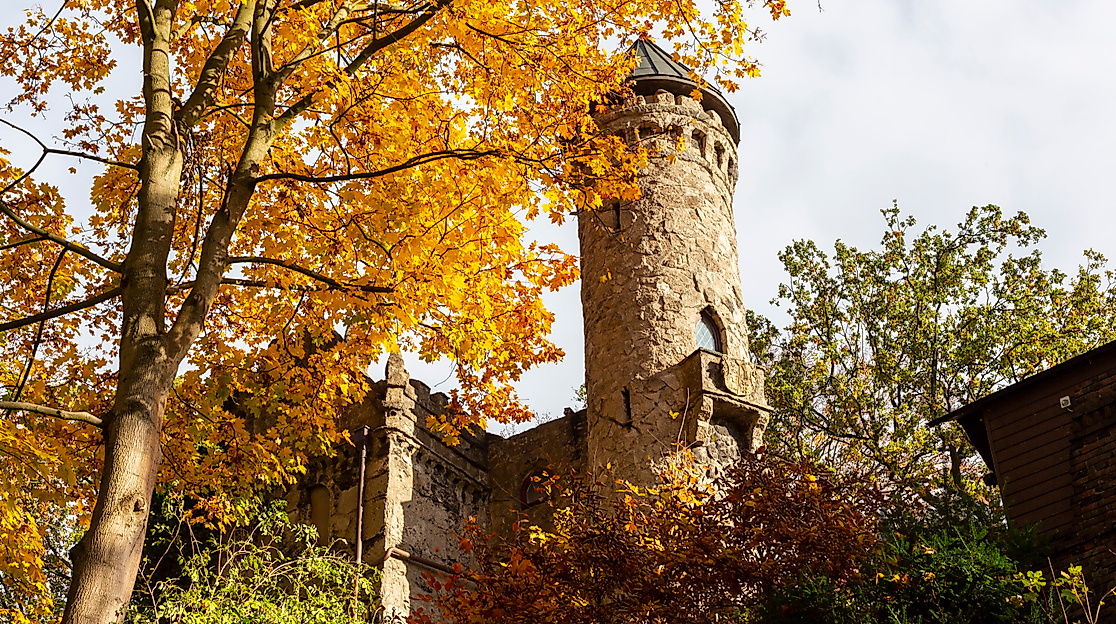 Burg Henneberg in Hamburg-Marienthal, herbstlich umgeben von gelb gefärbten Bäumen und historischem Rundturm.