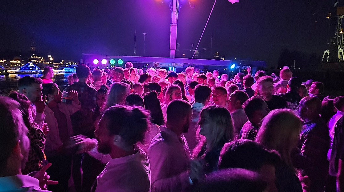 Das Partyschiff fährt durch den beleuchteten Hamburger Hafen