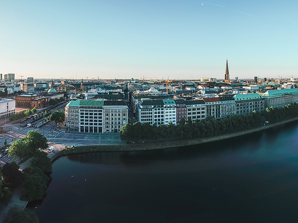 Panorama der Binnenalster bei Sonnenaufgang mit Blick auf Hamburgs Innenstadt und glitzerndem Wasser