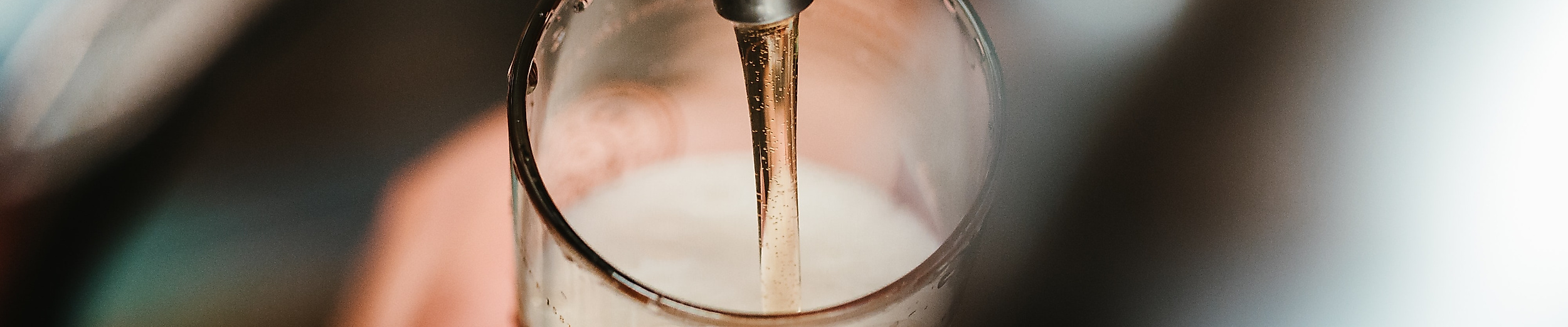 Frisch gezapftes Craft Beer fließt in ein Glas, Nahaufnahme an der Theke im Hamburger Nachtleben