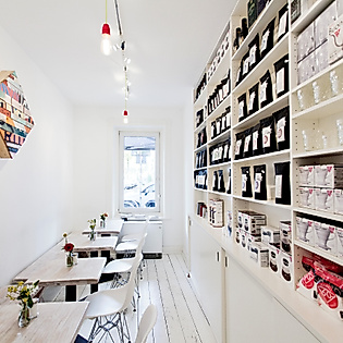 Heller Innenraum des Stockholm Espresso Club in Hamburg mit Kaffeespezialitäten, Regalen und minimalistischer Einrichtung