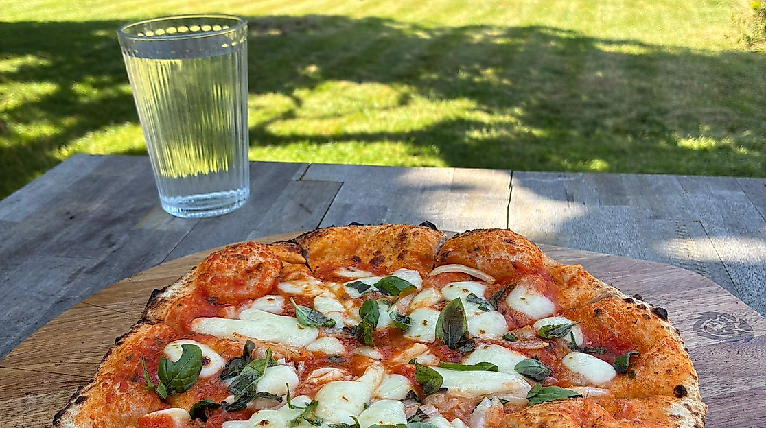 Eine Pizza auf einem Gartentisch
