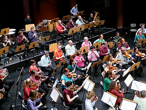 Spielendes Orchester in bunter Kleidung von der Seite
