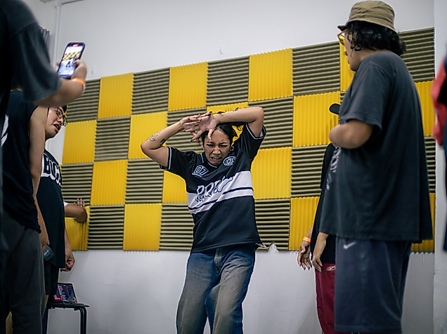 Several dancers in one picture, with a krump dancer dancing in the middle.